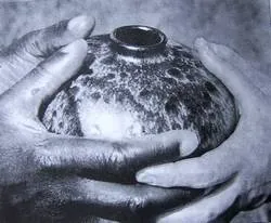 Zwei Hände halten vorsichtig einen texturierten, runden Keramiktopf.