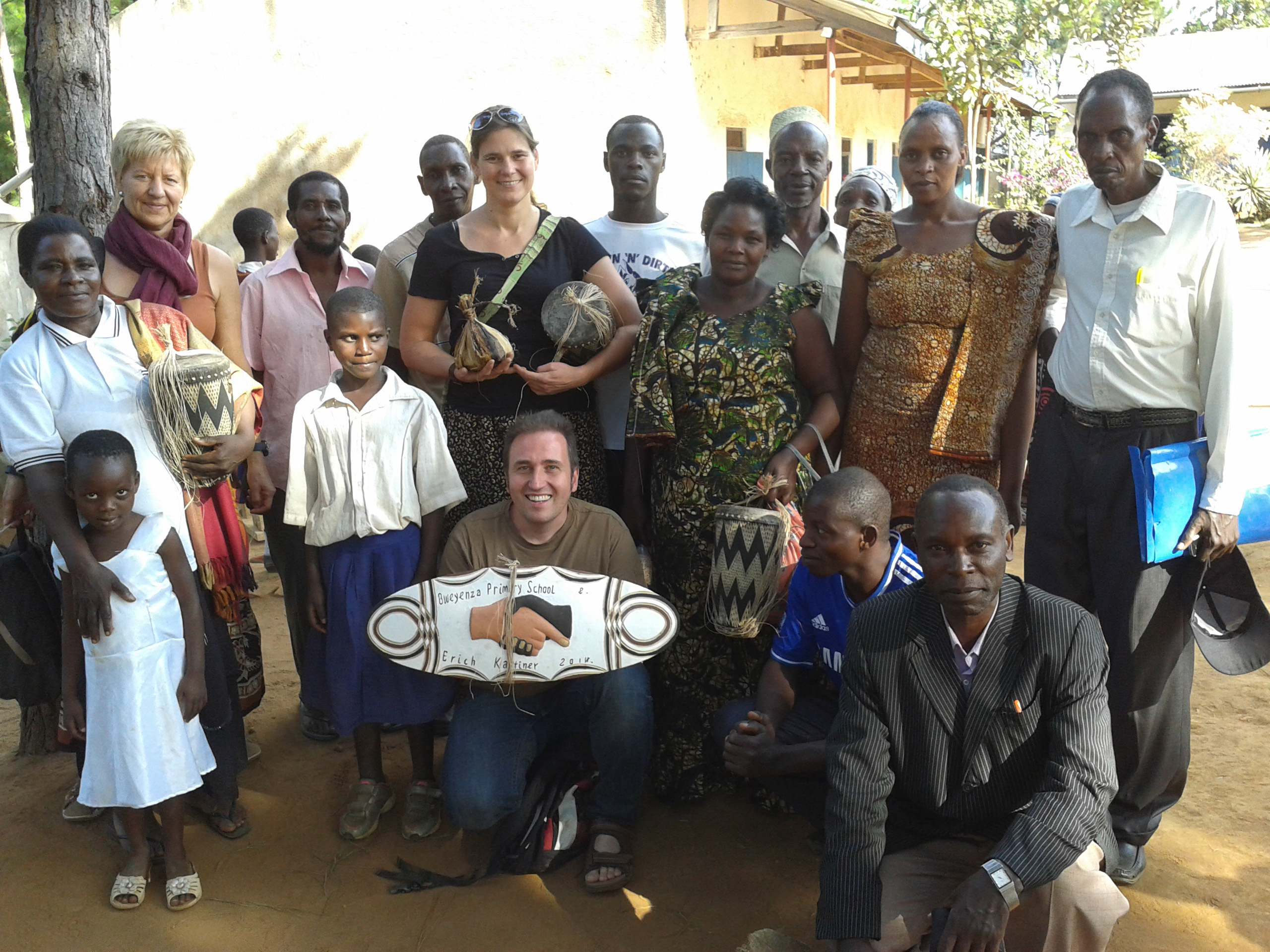 Gruppenfoto mit Europäern und Tansaniern, Handwerk haltend und "Success Primary School" Schild.