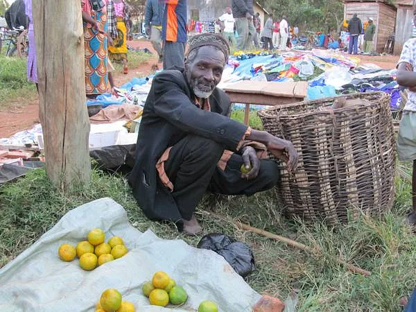 Gruppe von Erwachsenen und Kindern versammelt in einer einfachen, ländlichen 