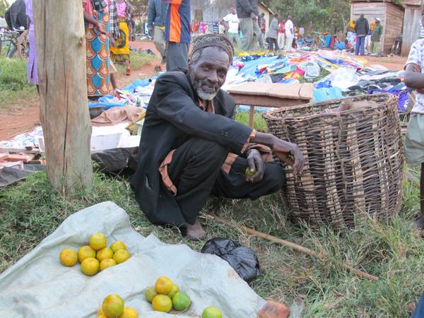 Gruppe von Erwachsenen und Kindern versammelt in einer einfachen, ländlichen 
