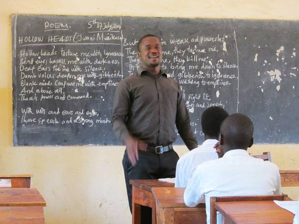 Gruppe von Erwachsenen und Kindern versammelt in einer einfachen, ländlichen 